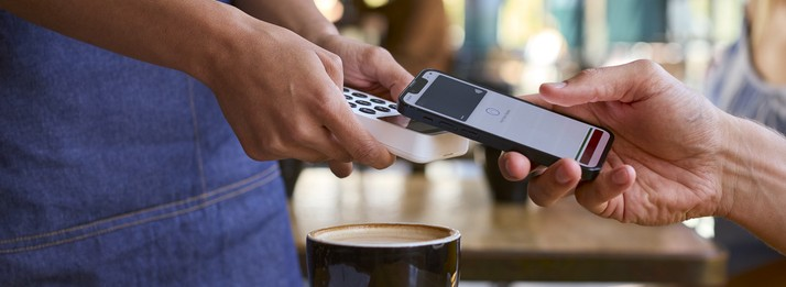 A person using apple phone pay to pay for coffee