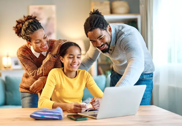 Parents and child learning on laptop together