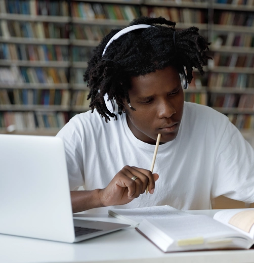 Headphones on head with laptop and book
