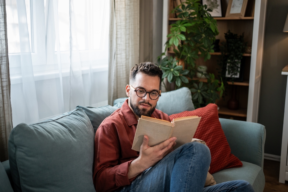 Man reading book on couch