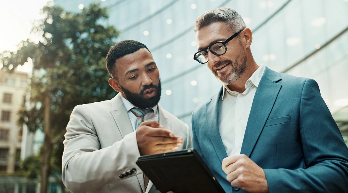 Two men looking at an ipad