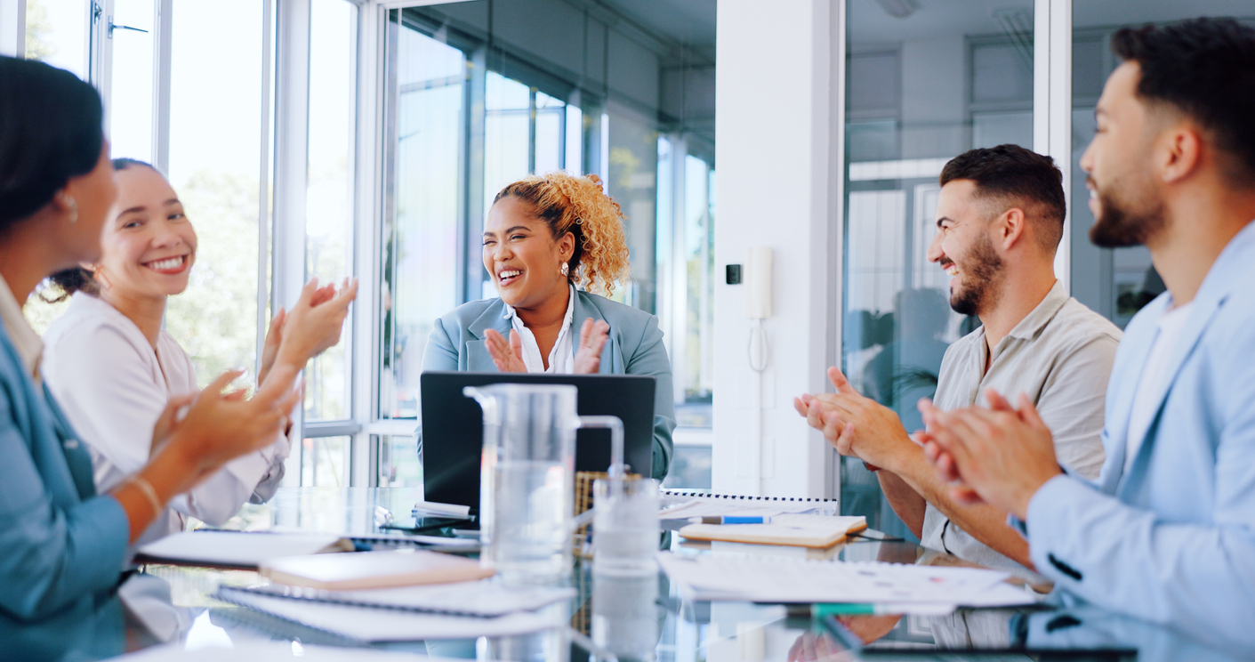 Happy coworkers clapping in a meeting
